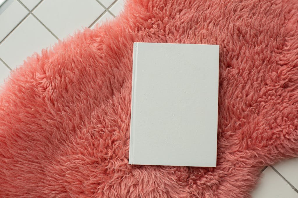 Blank white notebook placed on pink carpet