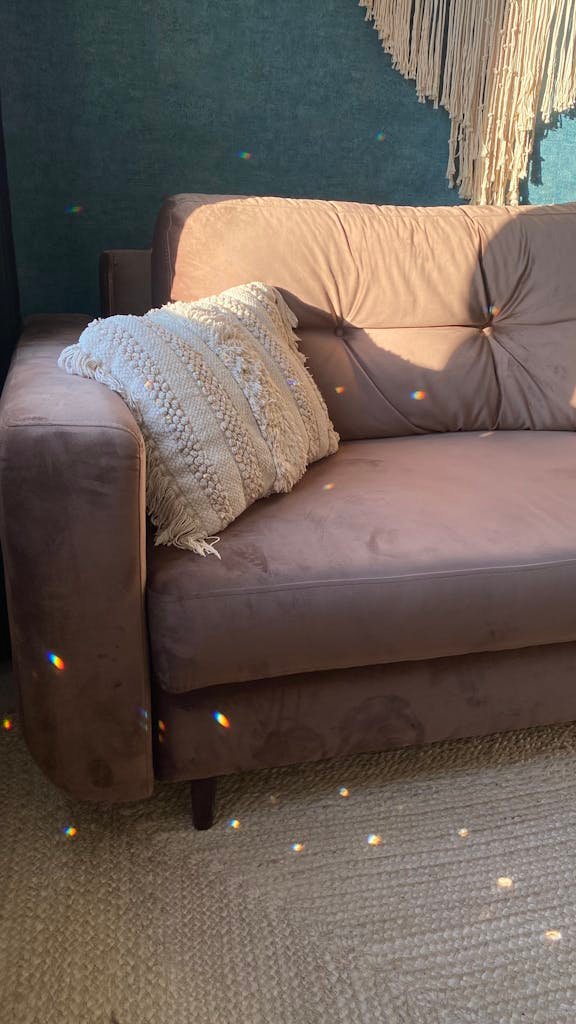 A Throw Pillow on the brown Sofa above a sisal rug