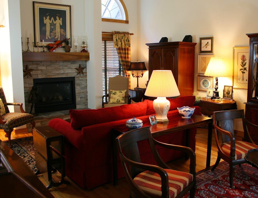 Brown Wooden Console Table Next to Red Loveseat on the oriental rug