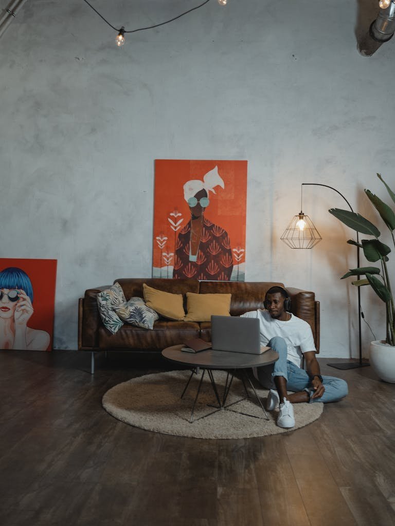 Man Sitting on the rug while Using His Laptop