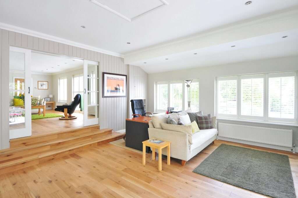 a living room with a couch, rug and a desk